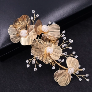 Golden flower bridal headpiece with white pearls on a black background for weddings