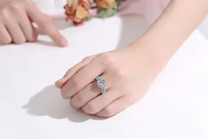 Close-up of 2 carat moissanite silver ring on hand with six-prong setting and pavé band