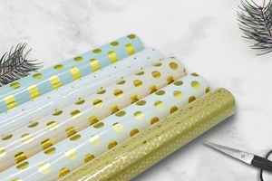 Detail view of five assorted gold foil dot and geometric gift wrapping paper rolls