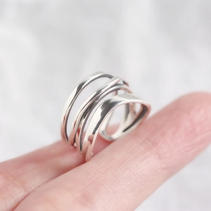 Dettaglio ravvicinato di un anello multistrato in argento sterling S925 sulle dita