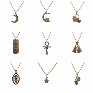 Sammlung von goldenen Herz-, Kreuz- und Sternanhängern mit Kristallen auf weißem Hintergrund