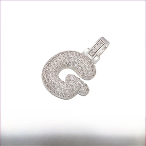Macro detail of iced-out letter G pendant in rhodium-plated brass with zirconia stones