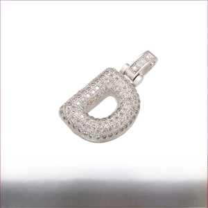 Macro view of iced out silver letter D pendant made of rhodium plated brass and zircon
