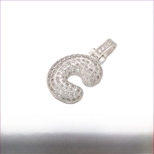 Macro detail of iced-out letter C pendant with sparkling stones and wide bail