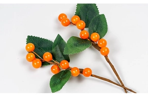Detailed view of artificial orange berry branches with green leaves for home decor