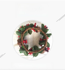 Detail van rode bessen, dennenappels en groene bladeren op deze kerstkrans voor kaarsen