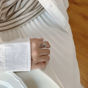 Close-up of a minimalist 925 sterling silver irregular wavy ring worn by a model