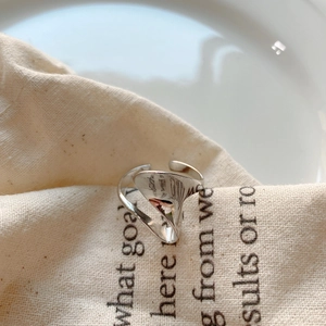 Detail view of silver 925 irregular liquid metal open ring on soft linen fabric