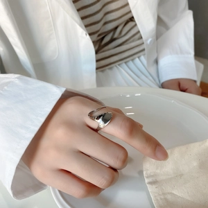 Detail of irregular liquid silver ring on model finger showing unique adjustable design