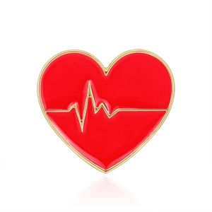 Dettaglio della spilla a cuore in smalto rosso con linea del battito cardiaco dorata