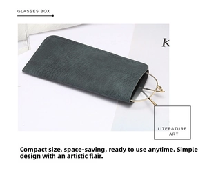 Gros plan d'un étui à lunettes en cuir gris mat avec des lunettes à monture dorée