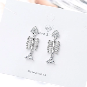 Silver fishbone earrings with sparkling cubic zirconia on a white jewelry card