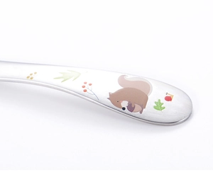 Macro shot of a 304 stainless steel spoon handle with cute cartoon squirrel and leaf patterns