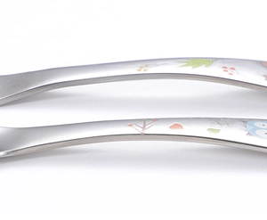 Detailed close-up of 304 stainless steel spoons featuring colorful owl and plant patterns