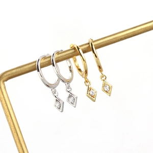 Detail showing gold and silver geometric rhombic hoop earrings with sparkling cubic zirconia