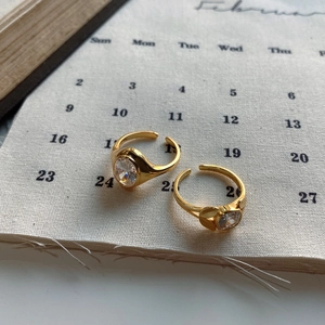 Detail of S925 sterling silver gold rings with oval zircon and heart pattern on canvas