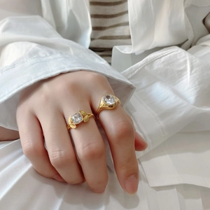 Detail of vintage gold 925 silver rings with large zircon stones on model's fingers