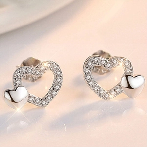 Macro detail of silver double heart earrings with shimmering cubic zirconia settings