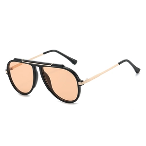Modern aviator sunglasses with gold metal temples and orange tinted lenses on white background
