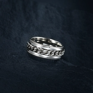 Macro shot of silver rotating chain ring on natural dark stone texture background