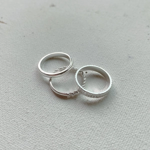 Detailed shot of 925 sterling silver ring set with polished, beaded, and vertical textures