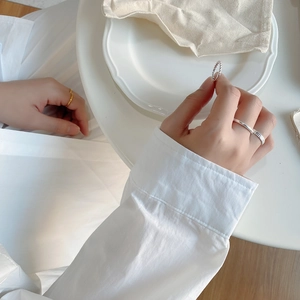 Detail showing minimalist 925 sterling silver rings stacked on model's hand