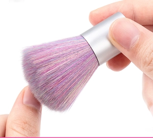 Close-up of a compact nail dust brush with soft purple and pink gradient bristles