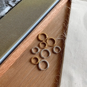 Minimalist 925 sterling silver hoop earrings in gold and silver on a wooden tray