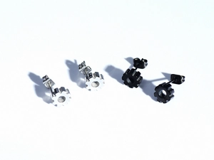 Detailed macro view of industrial gear stud earrings in black and silver finishes