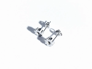 Macro shot of industrial style silver gear earrings made of premium titanium steel