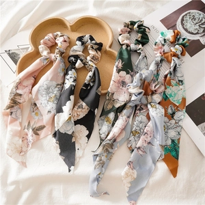 Flat lay of vintage floral silk satin scrunchies with long ribbons in multiple colors