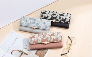 Detailed view of long PU leather wallets featuring floral patterns and gold metal clasps