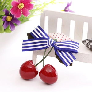 Japanese style cherry hair clip with blue striped bow on a white decorative bench
