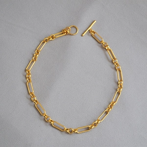 Detalle de collar de cadena de clips dorados con cierre de palanca OT minimalista