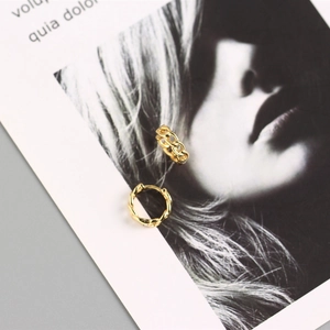 Close-up of gold chain-link hoop earrings displayed on an artistic portrait card