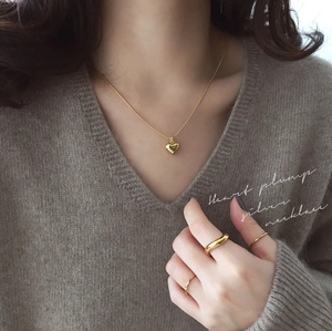 Detail of a polished gold heart pendant necklace on S925 sterling silver snake chain