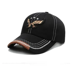 Detail of embroidered eagle and brown leather brim trim on a black baseball cap
