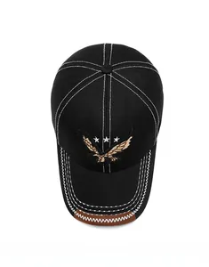 Close-up of black cotton baseball cap with eagle embroidery and white contrast stitching