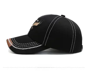Detail of double white stitching and eagle embroidery on black canvas baseball cap