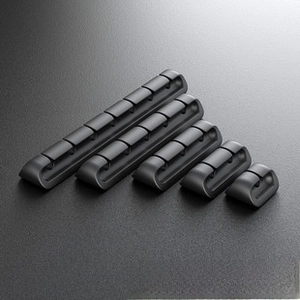 Detailed set of black silicone cable organizers in various multi-hole sizes for desks