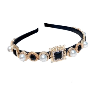 Detailed view of baroque headband with gold filigree frames, black gems and white pearls