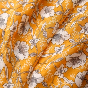 Detailed macro shot of floral print on breathable yellow cotton linen scarf fabric