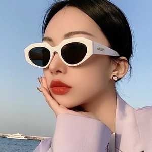 Chic white irregular frame sunglasses with dark lenses worn outdoors against a blue sky