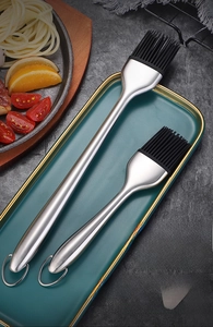 Detail of 304 stainless steel silicone oil brush set on a green plate for kitchen BBQ
