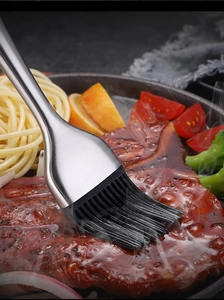 Detailed close-up of a silicone basting brush with a steel handle brushing sauce onto steak
