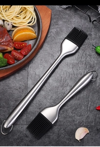 Two heat-resistant silicone basting brushes with 304 stainless steel handles on dark stone