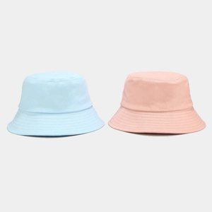 Close-up of fine stitching and cotton fabric on sky blue and pink bucket hats