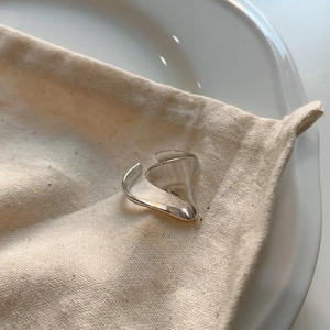 Close-up of irregular 925 sterling silver ring resting on a textured cotton pouch