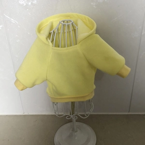 Detail view of yellow pet hoodie with soft fleece fabric on white mannequin stand