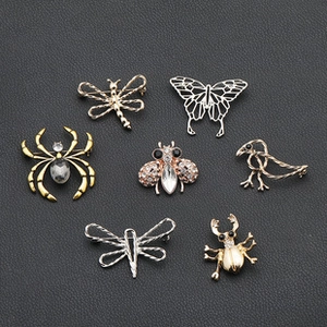 Detail of seven mixed metal insect brooches including bee and dragonfly on black leather